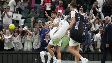 El serbio Novak Djokovic y el polaco Hubert Hurkacz abandonan la cancha luego de que su encuentro fuera suspendido debido a lo tarde que se jugaba en el campeonato de tenis de Wimbledon en Londes. Domingo 9 de julio de 2023. (AP Foto/Kirsty Wigglesworth)