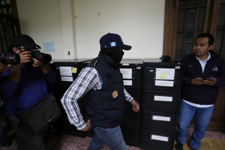 Un miembro de la Fiscalía General de Guatemala allana la sede de la autoridad electoral del país horas después de que certificara los resultados de las elecciones del 25 de junio en la Ciudad de Guatemala, el jueves 13 de julio de 2023. (AP Foto/Moisés Castillo)