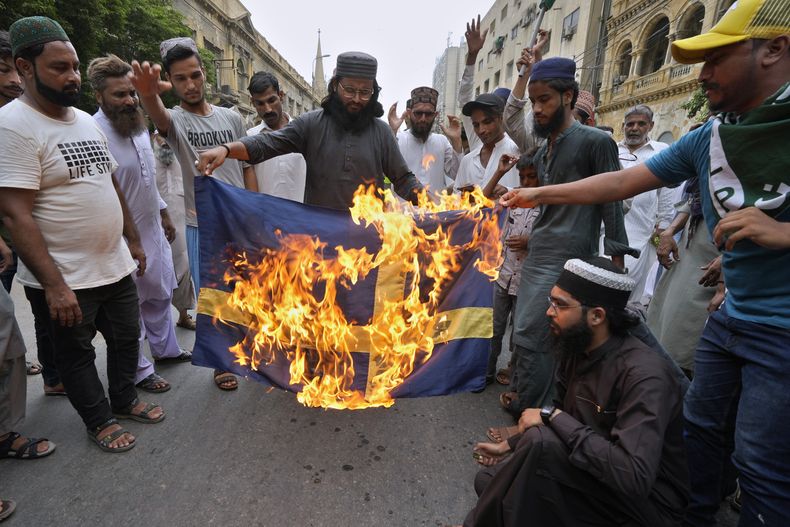 Partidarios del partido islamista radical Tehreek-e-Labaik Pakistan queman una bandera sueca para denunciar la quema del Corán en Suecia, en Karachi, Pakistán, el 7 de julio de 2023. (Foto AP/Fareed Khan, Archivo)