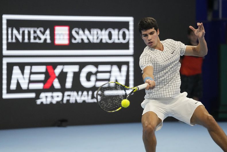 ARCHIVO - Carlos Alcaraz devuelve ante Sebastián Báez en las semifinales del torneo Next Gen de la ATP en Milán, el viernes 12 de noviembre de 2021. (AP Foto/Antonio Calanni)