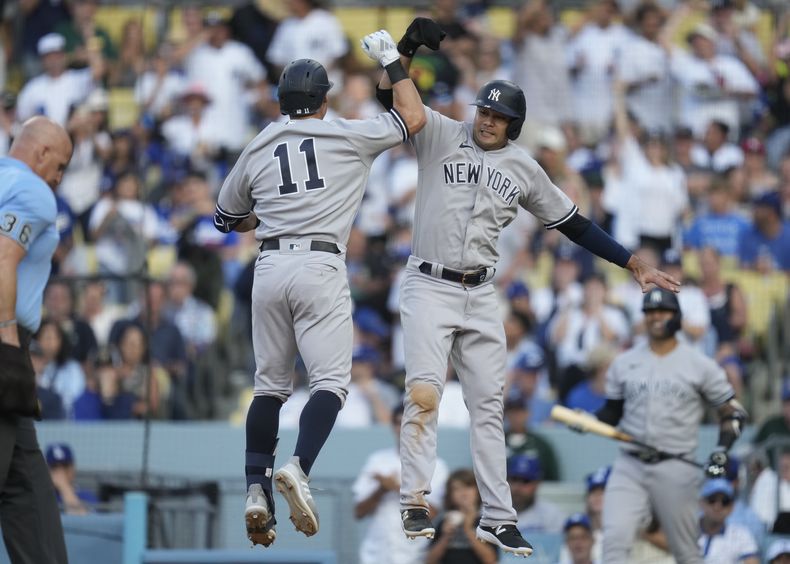 Anthony Volpe (11), de los Yanquis de Nueva York, celebra con Isiah Kiner-Falefa (12) después de que ambos anotaron con cuadrangular de Volpe durante la novena entrada del juego de béisbol en contra de los Dodgers de Los Ángeles, en Los Ángeles, el domingo 4 de junio de 2023. (AP Foto/Ashley Landis)