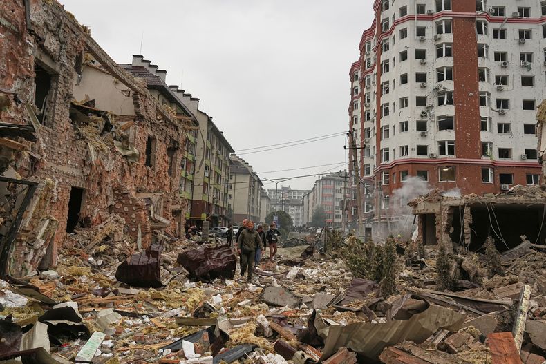 Gente camina cerca de edificios de apartamentos dañados después de un ataque ruso en Kiev, Ucrania, el domingo 28 de septiembre de 2025. (AP Foto/Efrem Lukatsky)