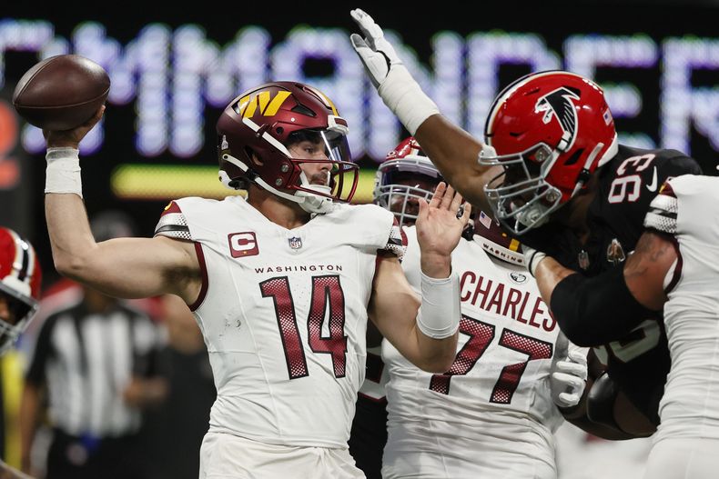El quarterback de los Commanders de Washington Sam Howell trabaja baja presión frente al defensive tackle de los Falcons de Atlanta Calais Campbell en el encuentro del domingo 15 de octubre del 2023. (AP Foto/Butch Dill)