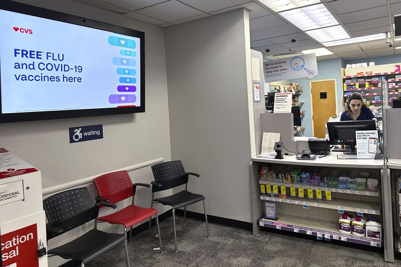Un letrero en el que se ofrecen vacunas contra la gripe y el COVID-19 aparece en una pantalla de una farmacia, el martes 13 de febrero de 2024, en Buffalo Grove, Illinois. (AP Foto/Nam Y. Huh, archivo)