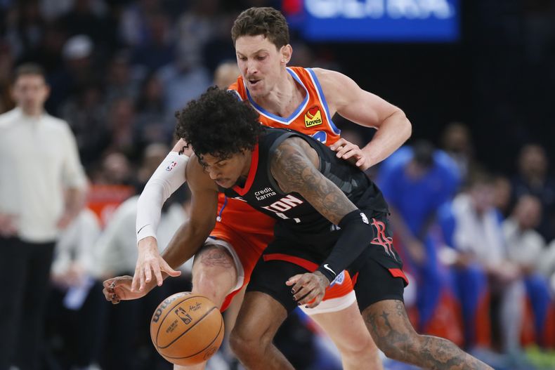 El centro del Oklahoma City Mike Muscala (atrás), intenta robar el balón al armador de los Rockets de Houston, Jalen Green durante la primera mitad del juego de baloncesto de la NBA, el miércoles 27 de marzo de 2024, en Oklahoma City. (AP Foto/Nate Billings)