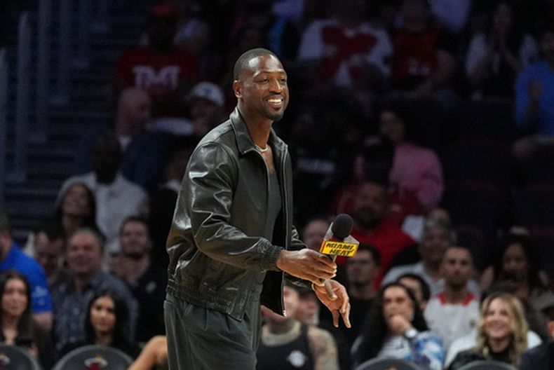 La leyenda del Heat de Miami, Dwyane Wade, camina a un costado de la duela durante un tiempo fuera mientras observa el partido de baloncesto de la NBA entre el Heat de Miami y los Mavericks de Dallas, el lunes 26 de octubre de 2026, en Miami. (AP Foto/Rebecca Blackwell)
