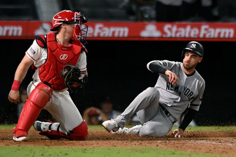 Cody Bellinger, de los Yankees de Nueva York, se desliza para anotar frente al catcher Tyler Heineman, de los Angelinos de Los Ángeles, en la décima entada del juego del miércoles 2 de septiembre de 2026 (AP Foto/Wally Skalij)
