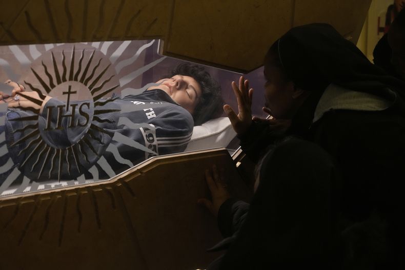 ARCHIVO - El cuerpo de Carlo Acutis, un joven italiano que murió en 2006 a causa de una leucemia, yace en su tumba en Asis, Italia, el 1 de marzo de 2025. (AP Foto/Gregorio Borgia, archivo)