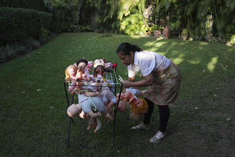 Irelis Baldirio pone a secar muchas usadas lavada en la organización sin fines de lucro Hospital de los Peluches, en donde recuperan y reparan juguetes usados para donarlos a niños vulnerables como regalos de Navidad, en Caracas, Venezuela, el jueves 5 de diciembre de 2024. (AP Foto/Ariana Cubillos)