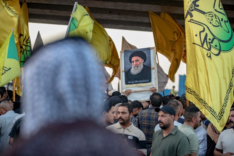 Un manifestante sostiene un retrato del principal clérigo chií, el gran ayatolá Ali al-Sistani, durante una protesta contra la suspensión de los vuelos entre Irak e Irán, en el exterior del Aeropuerto Internacional Najaf, en Najaf, Irak, el 28 de septiembre de 2026. (AP Foto/Anmar Khalil)