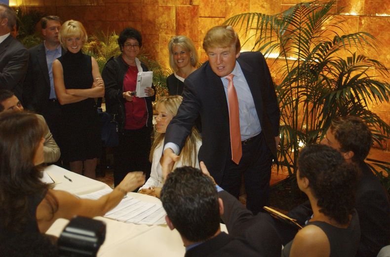 ARCHIVO - Donald Trump saluda a posibles candidatos del reality The Apprentice en el primer día de audiciones para la próxima temporada del programa el 30 de julio de 2004, en Nueva York. Versiones sobre el comportamiento de Trump en The Apprentice han hecho resurgir acusaciones de su supuesto maltrato a los concursantes negros del programa. (Foto AP/Jennifer Szymaszek, archivo)