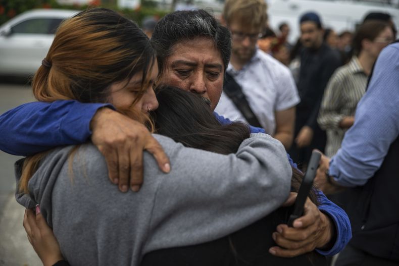 Jaslyn Hernandez, hija de un trabajador de un lavado de autos, abraza a su hermana Kimberly Hernandez, y a su tío Juan Medina durante una conferencia de prensa con las familias de los trabajadores del lavado de autos detenidos por los agentes federales de inmigración, el miércoles 11 de junio de 2025, en Culver City, California. (AP Foto/Ethan Swope)