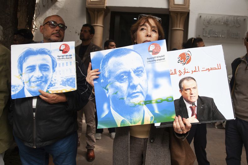 Manifestantes sostienen carteles con fotos de detenidos durante una concentración en el exterior de un juzgado en Túnez, el 4 de marzo de 2025, para exigir la liberación de los acusados en un caso de conspiración contra la seguridad del estado. (AP Foto/Ons Abid)