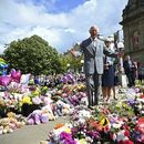 El rey Carlos III de Gran Bretaña mira ofrendas frente al Ayuntamiento de Southport, en Southport, Inglaterra, el martes 20 de agosto de 2024, mientras se reúne con miembros de la comunidad local, luego del ataque del 29 de julio en una clase de baile infantil. (Paul Ellis/Pool vía AP)