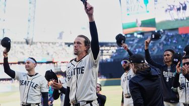 Los jugadores de los Marineros de Seattle, entre ellos el abridor Logan Gilbert, saludan al narrador de radio Rick Rizzs previo al último juego de su carrera ante los Angelinos de Los Ángeles, el domingo 27 de septiembre de 2026, en Seattle. (AP Foto/Lindsey Wasson)