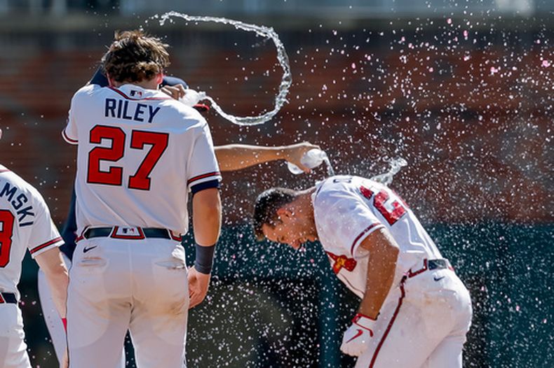 Matt Olson (derecha) recibe un baño tras batear el hit que le dio la victoria a los Bravos de Atlanta ante los Rockies de Colorado, el domingo 30 de agosto de 2026, en Atlanta. (AP Foto/Erik S. Lesser)