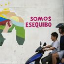 Un niño conduce una motocicleta por delante de un mural con el mapa de Venezuela, que incluye el territorio de Esequibo, en el vecindario 23 de Enero de Caracas, Venezuela, el 11 de diciembre de 2023. (AP Foto/Matías Delacroix)