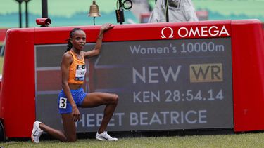 La keniata Beatrice Chebet posa junto a la imagen de su récord mundial en los 10.000 metros en el Clásico de Prefontaine en Eugene, Oregon, EE.UU. el sábado 25 de mayo del 2024. (AP Foto/Thomas Boyd)
