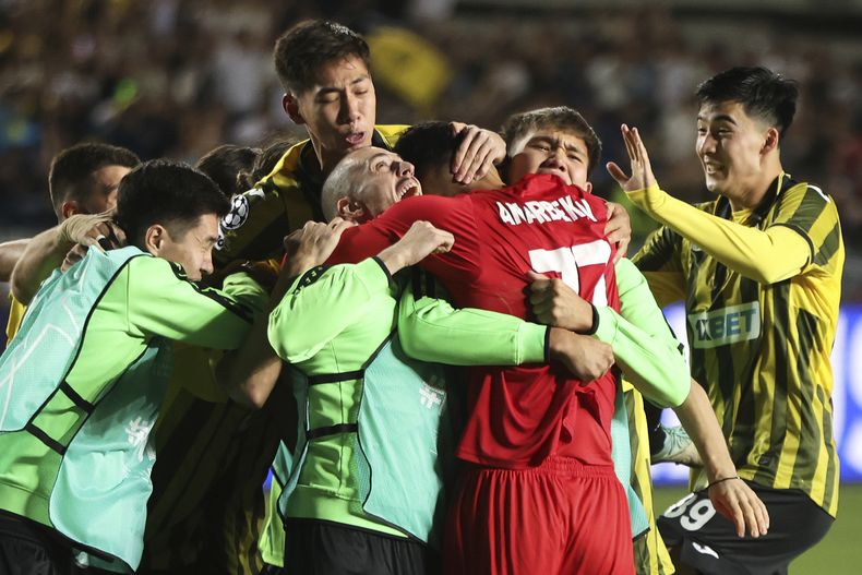 Jugadores del Kairat se avalanzan sobre el portero Temirlan Anarbekov tras vencer al Celtic en el playoff de la Liga de Campeones el miércoles 27 de agosto del 2025.(AP Foto/Alikhan Sariyev)