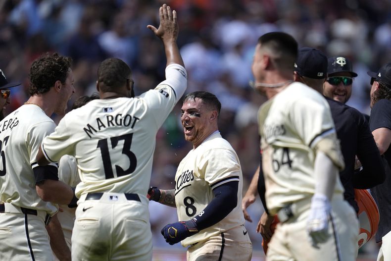 El puertorriqueño de los Mellizos de Minnesota, Christian Vázquez (8) celebra junto a sus compañeros de equipo mientras cruzaba el plato luego de conectar un cuadrangular para dejar tendido en el terreno a los Astros de Houston en el noveno episodio del juego de béisbol el domingo 7 de julio de 2024, en Mineápolis. (AP Foto/Abbie Parr)