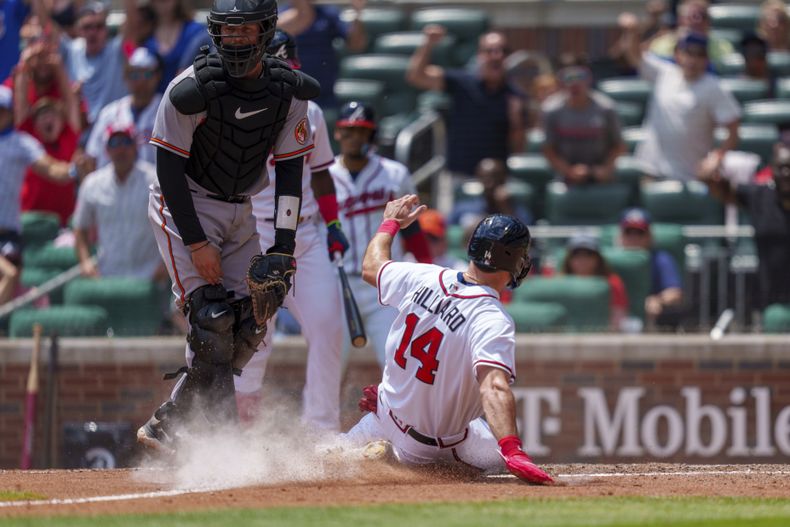 Sam Hilliard (14) de los Bravos de Atlanta se desliza en el plato en el 10mo inning del juego contra los Orioles de Baltimore, el domingo 7 de mayo de 2023. (AP Foto/Erik Rank)