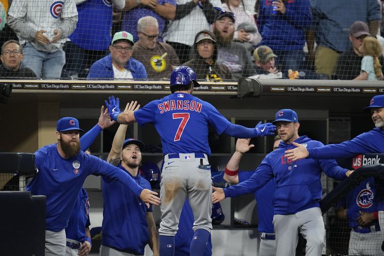 Dansby Swanson (7), de los Cachorros de Chicago, es felicitado en la caseta después de batear cuadrangular durante la quinta entrada del juego de béisbol en contra de los Padres de San Diego, el viernes 2 de junio de 2023, en San Diego. (AP Foto/Gregory Bull)