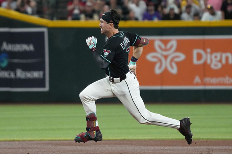 Corbin Carroll, de los Diamondbacks de Arizona, corre después de conectar un triple contra los Rockies de Colorado en la primera entrada del juego de béisbol de Grandes Ligas, el domingo 24 de mayo de 2026, en Phoenix. (AP Foto/Rick Scuteri)