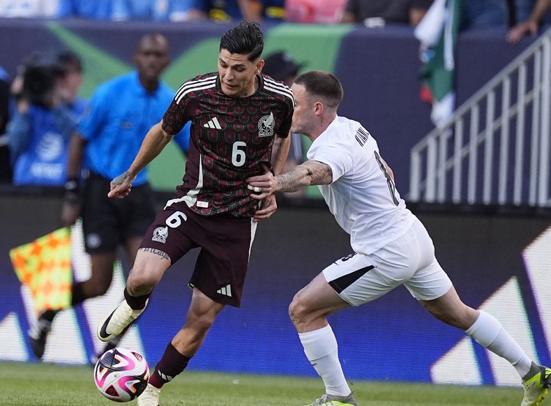 Gerardo Arteaga, zaguero de la selección mexicana, conduce el balón junto a Nahitán Michel, de Uruguay, durante un amistoso disputado el miércoles 5 de junio de 2024 en Denver (AP Foto/David Zalubowski)
