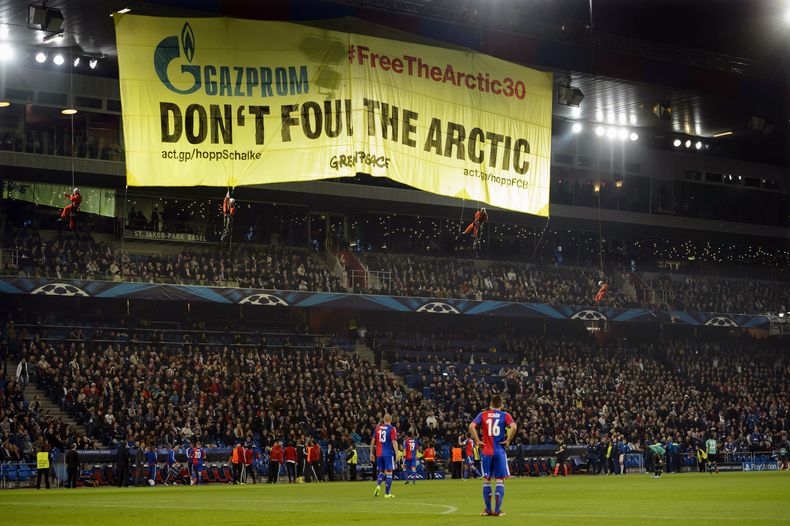 Activistas de Greenpeace muestran una pancarta durante un partido por la Liga de Campeones entre Basilea y Schalke el martes, 1 de octubre de 2013, en Basilea, Suiza. (AP Photo/Keystone, Laurent Gillieron)