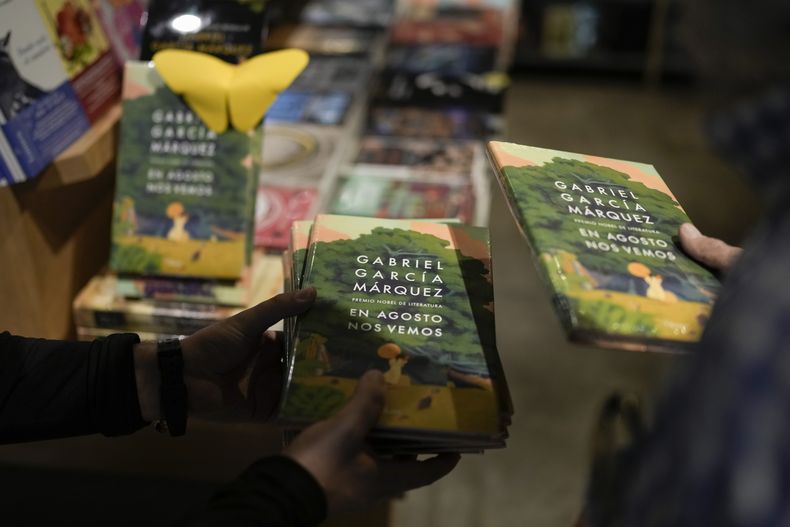 Un empleado con varios ejemplares de la novela póstuma En agosto nos vemos del autor colombiano Gabriel García Márquez en una fiesta de lanzamiento en una librería en la Ciudad de México el miércoles 6 de marzo de 2024. (Foto AP/Eduardo Verdugo)