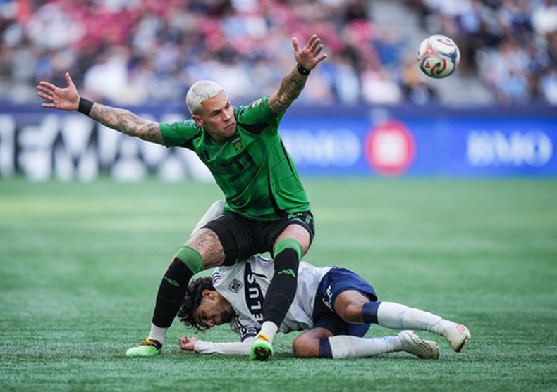 Christian Ramirez, arriba, de Austin FC, y Jeevan Badwal, de Whitecaps de Vancouver, chocan en la disputa del balón durante el segundo tiempo del partido de fútbol de la MLS, el domingo 13 de septiembre de 2026, en Vancouver, British Columbia. (Darryl Dyck/The Canadian Press via AP)