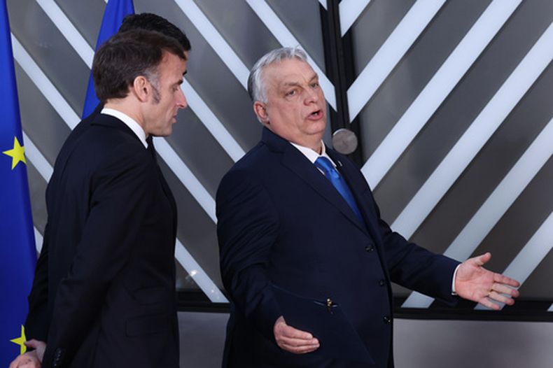 El presidente francés Emmanuel Macron y el primer ministro húngaro Viktor Orbán caminan después de una foto de grupo en la cumbre de la UE, en Bruselas, el 19 de marzo de 2026. (AP Photo/Omar Havana)