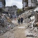 Dos personas caminan entre los escombros de viviendas destruidas por la ofensiva del ejército israelí contra Hamás, el miércoles 19 de febrero de 2025, en Jabaliya, en el norte de la Franja de Gaza. (AP Foto/Abdel Kareem Hana)
