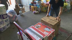 ARCHIVO - Veronica Yoo, voluntaria de Catholic Charities del Valle de Río Grande, carga cajas de donaciones en un carrito, en un almacén de McAllen, Texas el 24 de junio de 2018. (AP Foto/Manuel Valdes, Archivo)