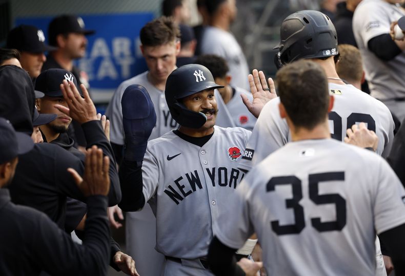 Trent Grisham de los Yankees de Nueva York es felicitado por sus compañeros en el dugout tras anotar con el doble de tres carreras de Anthony Volpe ante los Angelinos de Los Ángeles el lunes 26 de mayo del 2025. (AP Foto/Kevork Djansezian)
