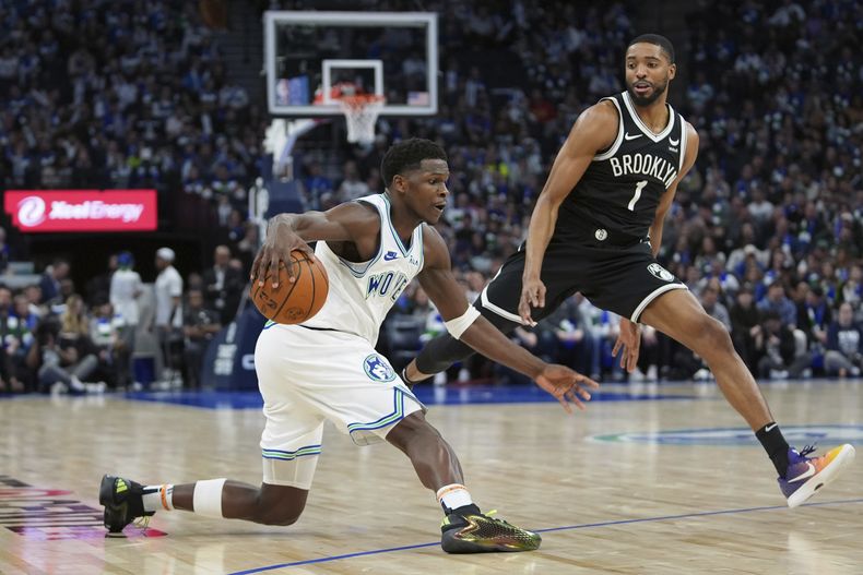 El escolta de los Timberwolves de Minnesota, Anthony Edwards, camina hacia la canasta mientras el alero de los Nets de Brooklyn Mikal Bridges (1) defiende durante la segunda mitad del partido de baloncesto de la NBA el sábado 24 de febrero de 2024 en Minneapolis. (AP Foto/Abbie Parr)