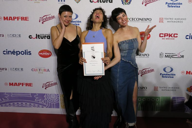 La actriz Paloma Petra, de izquierda a derecha, la directora Mayra Hermosillo y la actriz Natalia Plascencia de la película Vainilla posan con el premio del público a la mejor película de ficción en la ceremonia de premiación de la 23ª edición del Festival de Cine de Morelia, en Morelia, México, el viernes 17 de octubre de 2025. (Foto AP/Berenice Bautista)