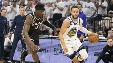 Stephen Curry de los Warriors de Golden State frente a Terence Davis de los Kings de Sacramento, el domingo 30 de abril de 2023, en Sacramento, California. (AP Foto/José Luis Villegas)