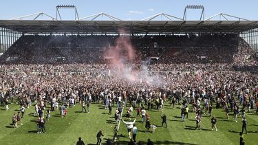 Los hinchas de St. Pauli irrumpen en la cancha tras vencer 3-1 a Osnabrück y lograr el ascenso a la Bundesliga, el domingo 12 de mayo de 2024, en Hamburgo. (Christian Charisius/dpa vía AP)