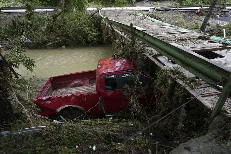 Un vehículo entre los escombros dejados por inundaciones, el lunes 16 de junio de 2025, en Valley Grove, Virginia Occidental. (AP Foto/Carolyn Kaster)