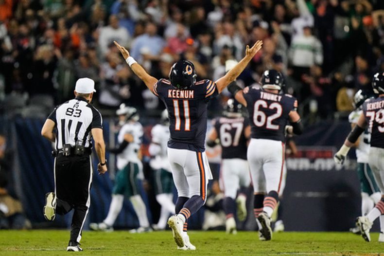 Case Keenum (11), quarterback de los Bears de Chicago, celebra después de lanzar un pase de touchdown a Kalif Raymond mientras el árbitro Shawn Hochuli (83) corre durante la segunda mitad del partido de la NFL en contra de los Eagles de Filadelfia, el lunes 28 de septiembre de 2026. (AP Foto/Nam Y. Huh)