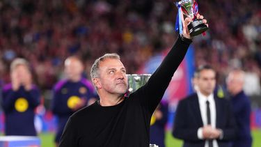 El entrenador del Barcelona Hansi Flick levanta su premio después de que el equipo conquistó La Liga con una victoria ante el Real Madrid el domingo 10 de mayo del 2026. (AP Foto/Joan Mateu Parra)