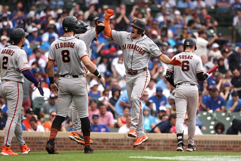 Matt Chapman, centro, de los Gigantes de San Francisco, celebra tras conectar un grand slam con sus compañeros de equipo Luis Arráez (1), Bryce Eldridge (8) y Willy Adames (2) durante la cuarta entrada del juego de béisbol de Grandes Ligas contra los Cachorros de Chicago en Wrigley Field, el viernes 5 de junio de 2026, en Chicago. (AP Foto/Geoff Stellfox)