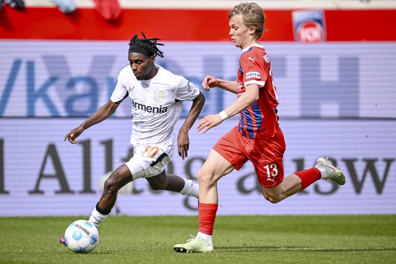 Jeremie Frimpong del Bayer Leverkusen y Frans Krätzig del Heideinheim pelean por el balón en el encuentro de la Bundesliga el sábado 5 de abril del 2025. (Harry Langer/dpa via AP)