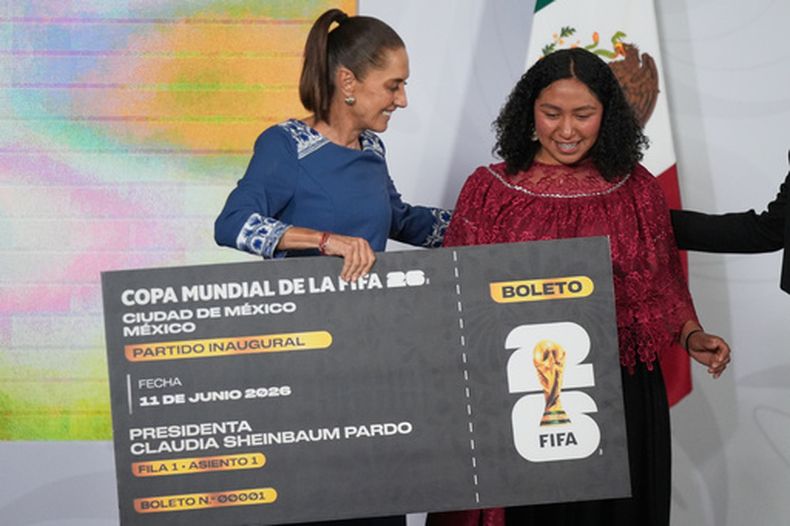 La presidenta mexicana Claudia Sheinbaum entrega un boleto simbólico para el partido inaugural del Mundial 2026 a la jugadora amateur Yolett Cervantes, el viernes 29 de mayo de 2026, en la Ciudad de México. (AP Foto/Fernando Llano)