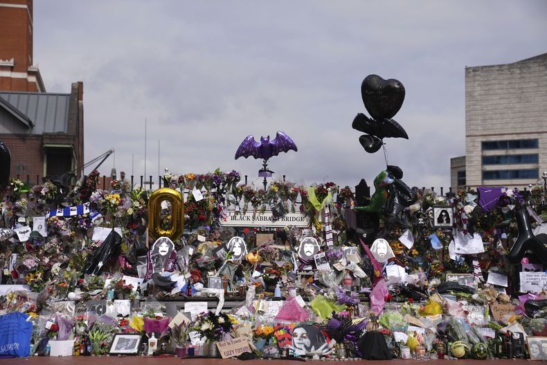 Ofrendas florales colocadas en el banco del puente Black Sabbath en Broad Street en memoria del líder de Black Sabbath, Ozzy Osbourne, antes de la procesión fúnebre, en Birmingham, Inglaterra, el miércoles 30 de julio de 2025. (Joe Giddens/PA via AP)