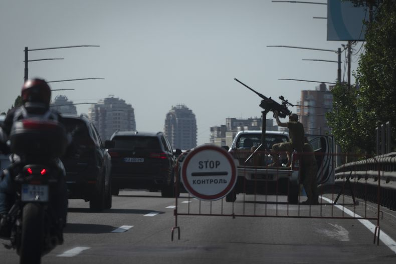 Soldados de Ucrania vigilan el cielo con una ametralladora en una avenida de la ciudad durante uno de los ataques rusos más masivos con misiles y drones contra blancos energéticos ucranianos, el lunes 26 de agosto de 2024, en Kiev, Ucrania. (AP Foto/Efrem Lukatsky)