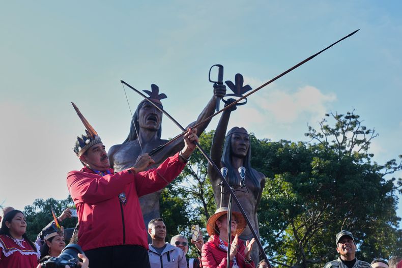El presidente Nicolás Maduro apunta con un arco y flecha durante el Día de los Indígenas, el domingo 12 de octubre de 2025, en Caracas, Venezuela. (AP Foto/Ariana Cubillos)
