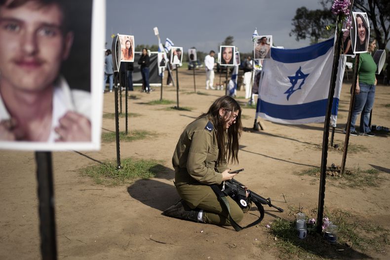 Una soldado israelí llora junto a un cartel que recuerda a una persona secuestrada el 7 de octubre en el ataque transfronterizo de Hamás contra el festival de música Nova, tras una conferencia de prensa en Reim, en el sur de Israel, el 5 de enero de 2024. (AP Foto/Maya Alleruzzo)
