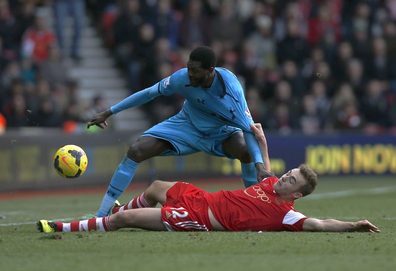 El futbolista de Tottenham Hotspur Emmanuel Adebayor, de pie, es frenado por Calum Chambers, de Southampton, durante un encuentro de la Liga Premier en Southampton el domingo 22 de diciembre del 2013. (AP Foto/Sang Tan)